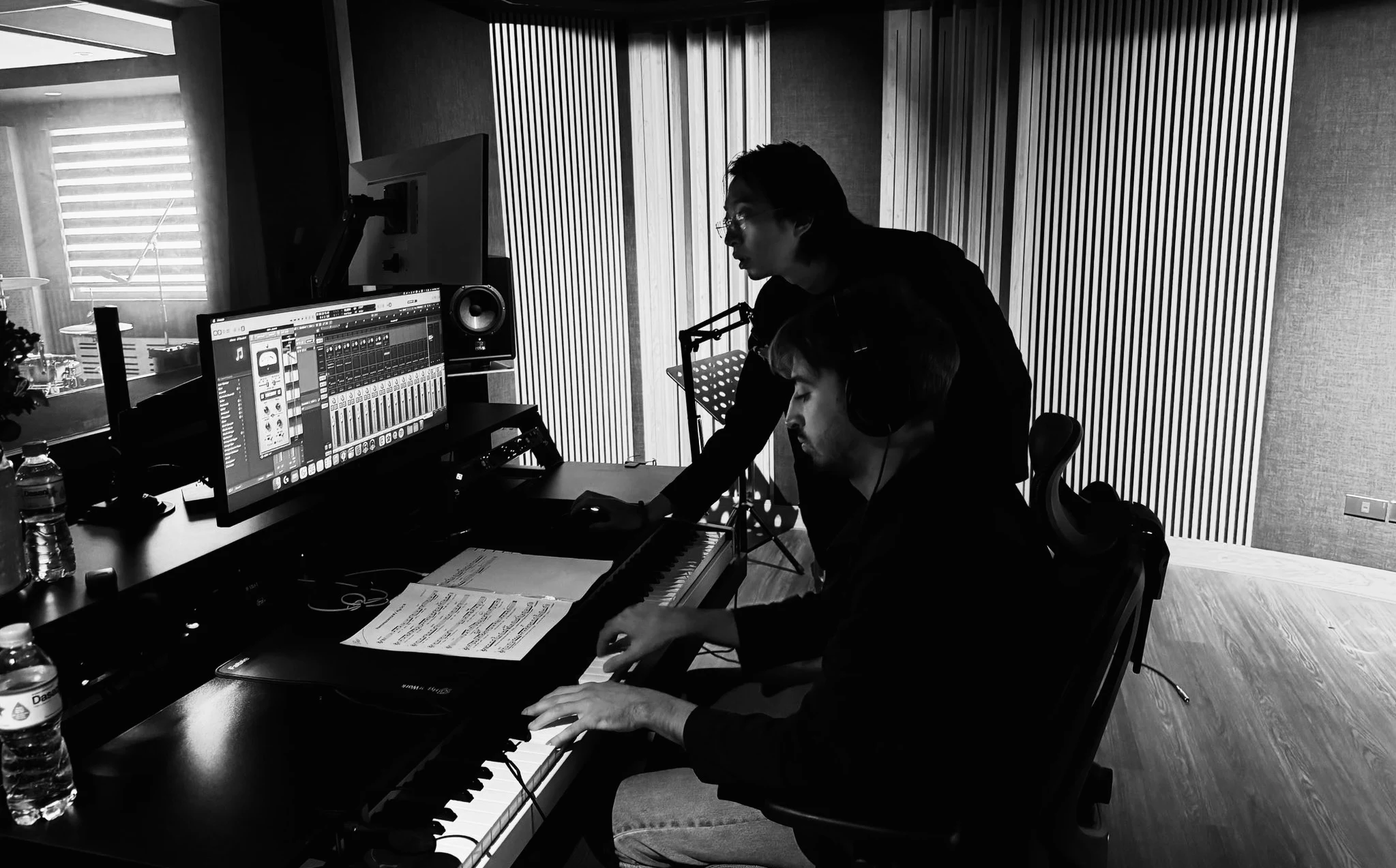Group of smiling students collaborating on a broadcast project in a recording studio.